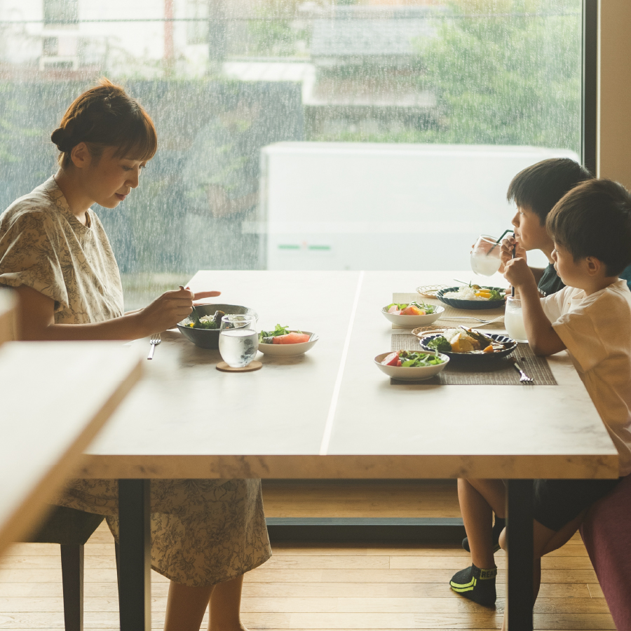 ASTEHOMEの窓際のテーブルで食事をする親子